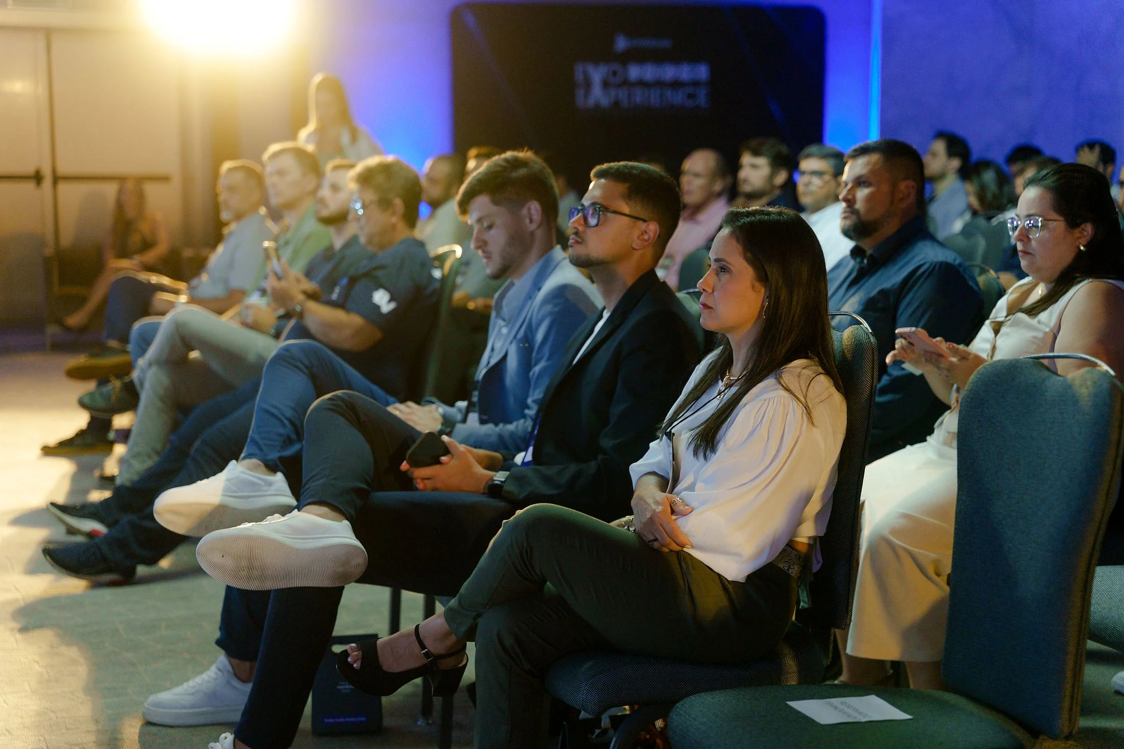 Franqueados acompanhando uma palestra da convenção de 2026, sala cheia